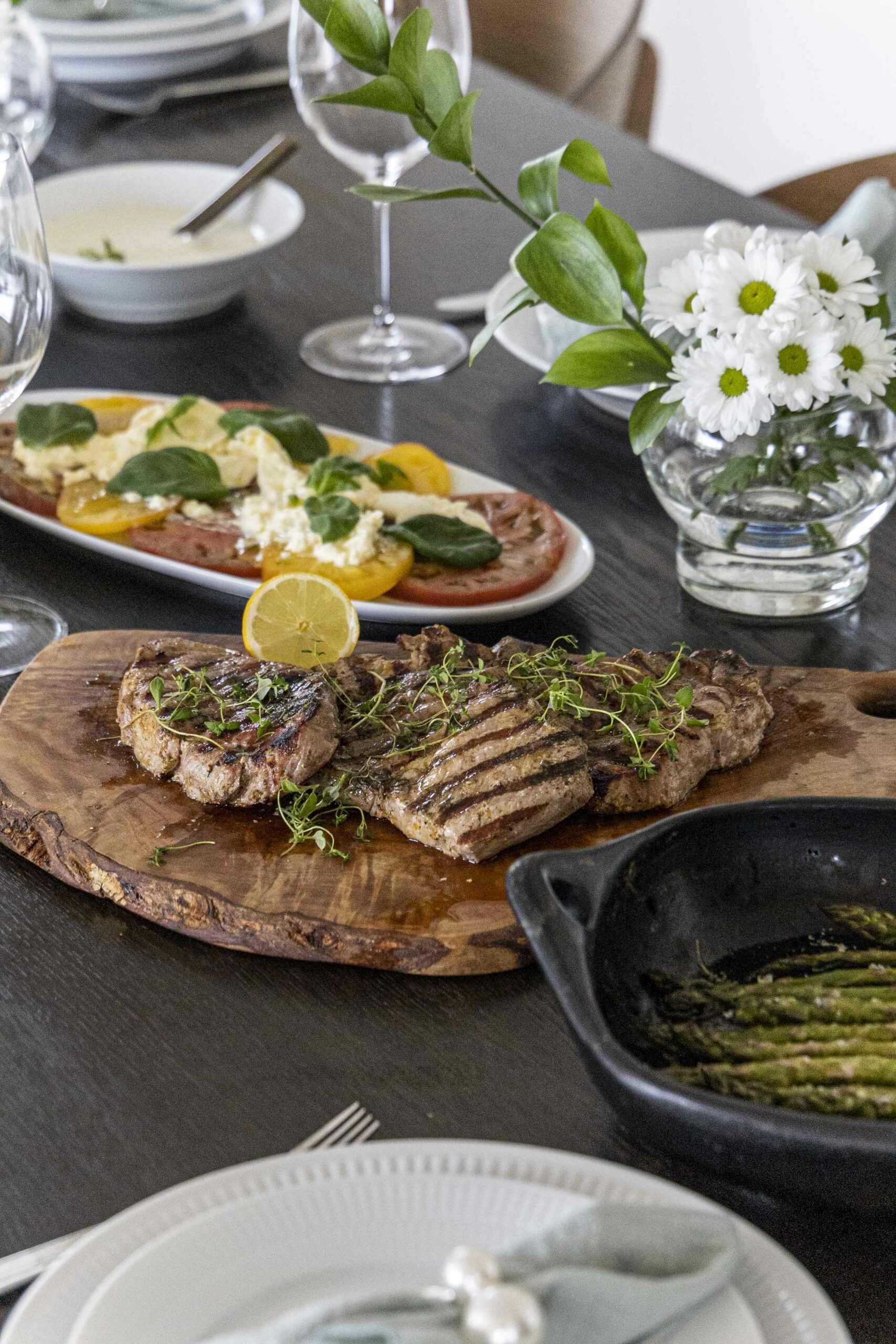 grillaðar grísahnakkasneiðar, tómatar með burrata og basil, bakaður aspas
