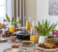 Bleikt Konudagsbrunch - Shakshuka - mimosa - pönnukökur - crossant - bleikar bollakökur