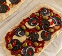 Pinsa pizza með svörtu pepperóní, ferskum mozzarella og basilíku